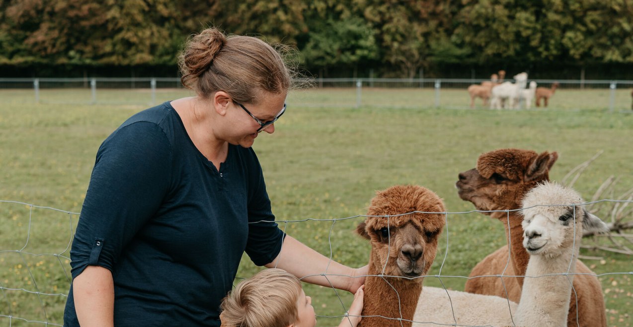 Mama und Kind streicheln Alpakas, © Inn-Salzach Tourismus Mama und Kind streicheln Alpakas, © Inn-Salzach Tourismus