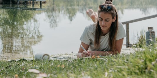 Frau liegt auf der Liegewiese am Peracher Badesee, © Inn-Salzach Tourismus