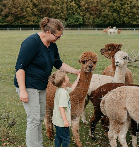 Mama und Kind streicheln Alpakas, &copy; Inn-Salzach Tourismus