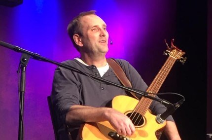 Tom Brückner sitzt auf einem Stuhl mit einer Gitarre, © Tom Brückner