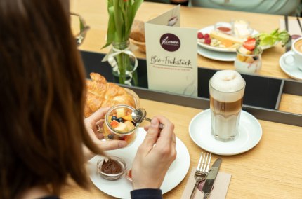 Müsli mit Obst und dazu einen Kaffee Latte, © Feinsinn - Bioladen & Genussküche