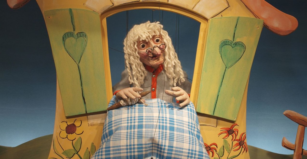 Ein Theater auf dem "Frau Holle" mit einem Kissen aus dem Fenster zu sehen ist, © Stefan Beyrer