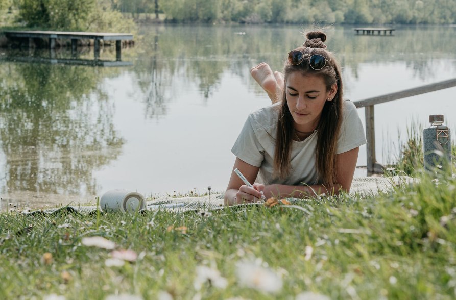 Frau liegt auf der Liegewiese am Peracher Badesee, &copy; Inn-Salzach Tourismus