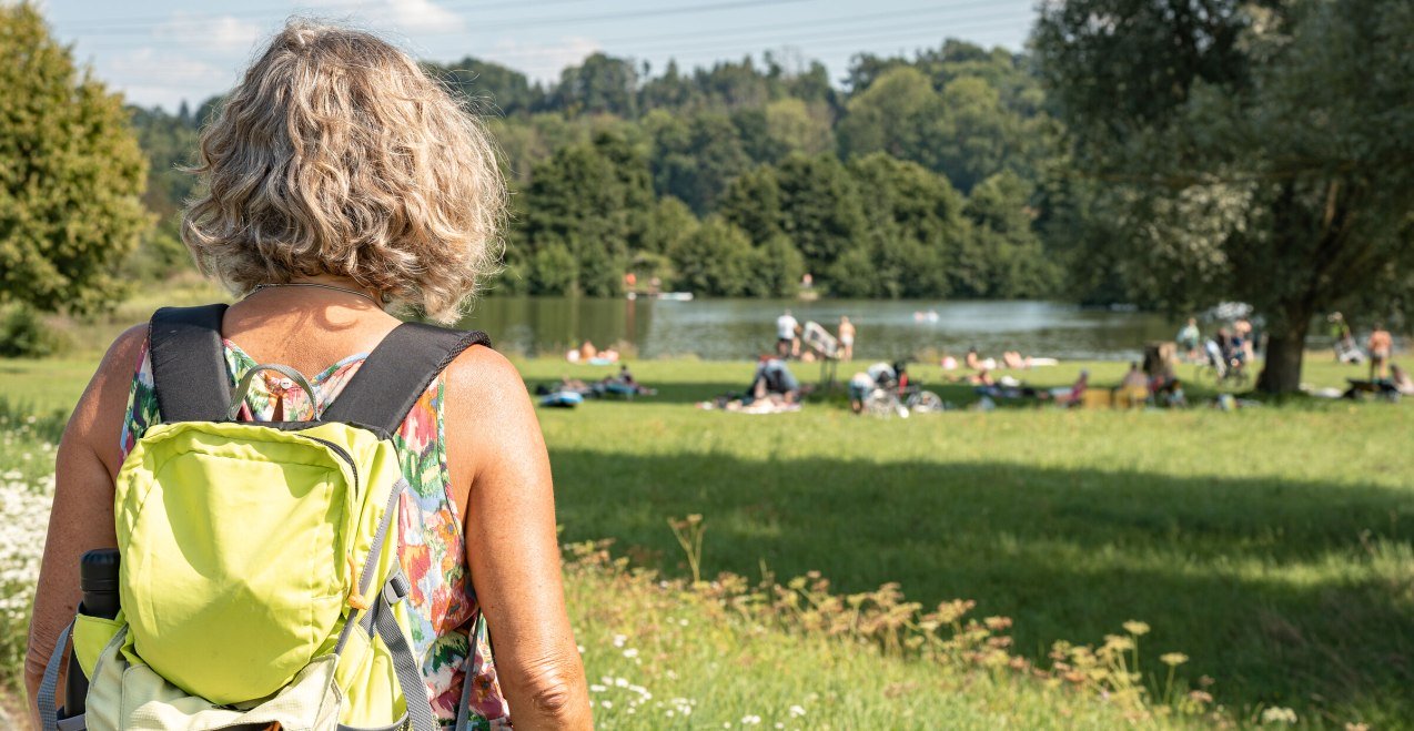 Frau mit Rucksack auf dem Weg zum Flossinger Badesee, © Inn-Salzach Tourismus