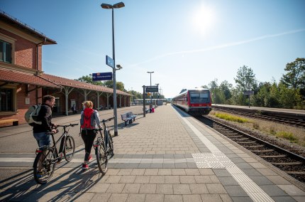 Zwei Radfahrer reisen am Bahnhof Alt&ouml;tting an.
