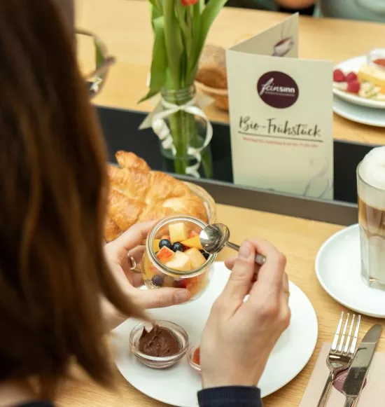 Müsli mit Obst und dazu einen Kaffee Latte, © Feinsinn - Bioladen & Genussküche