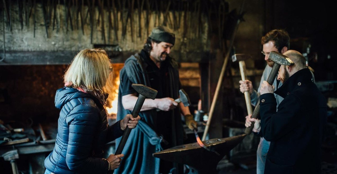 4 Personen schmieden zusammen