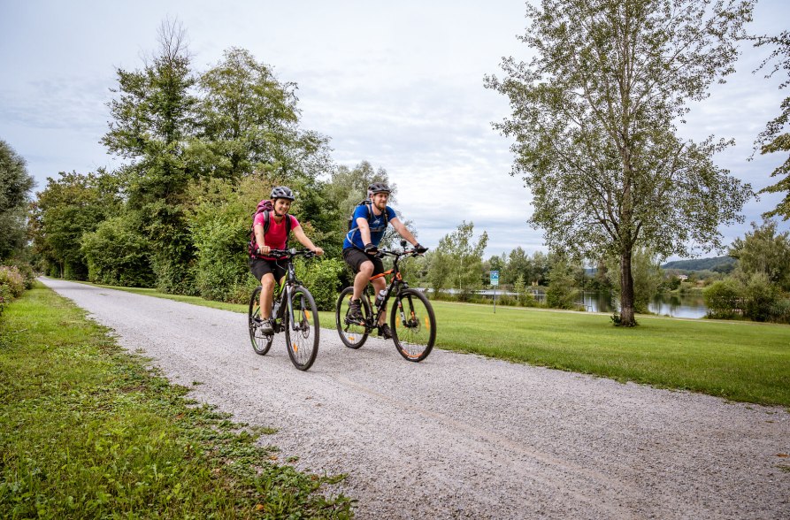 Radfahrer fahren entlang des Peracher Badesees, &copy; Inn-Salzach Tourismus