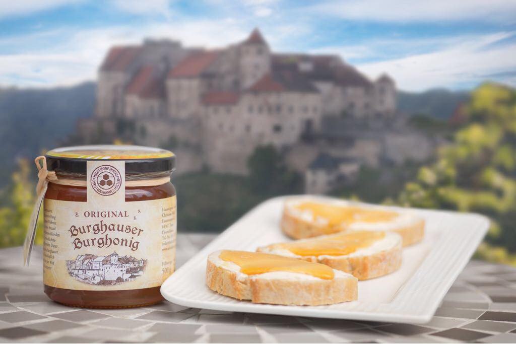 Der Burghonig der Imkerei Alztal-Honig vor der Burg Burghausen im Hintergrund